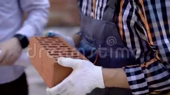 建造者手中的棕色砖块建筑工人手的特写镜头视频的预览图