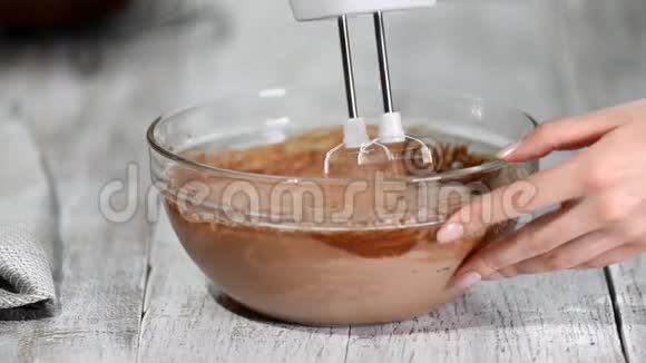 糖果师用手搅拌机敲打巧克力奶油烹饪巧克力奶油厨房视频的预览图