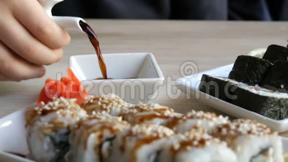餐厅桌上的盘子上摆着日本料理制作的美味的黑白寿司卷视频的预览图