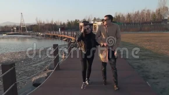 冰冻但幸福的一对情侣沿着海滨股票视频散步视频的预览图