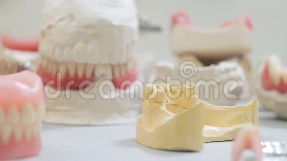 医生在牙科实验室的颌骨模型上戴了一个假牙视频的预览图