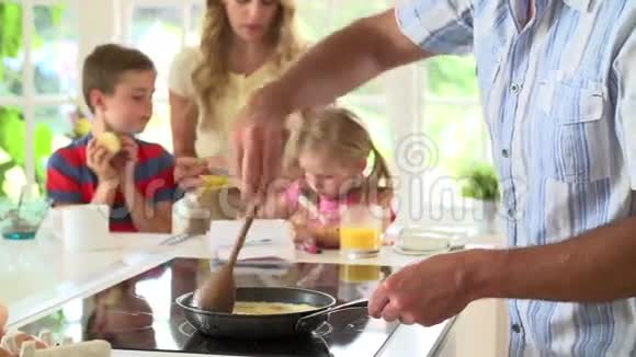 父亲在厨房为家庭早餐做炒蛋视频的预览图