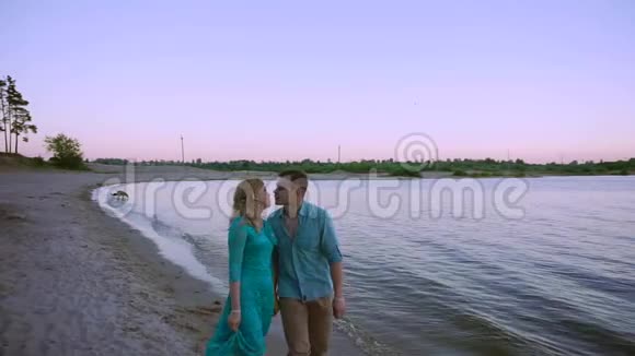 日落时分浪漫的情侣在海滩上散步视频的预览图