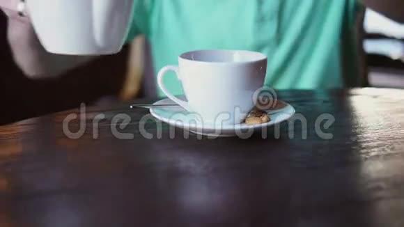 那个人坐在咖啡馆的一张小桌子旁那个人坐在桌子旁吃饭那个人看着窗外咖啡屋关门视频的预览图