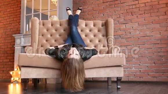 美丽的女人倒着头在沙发上放松视频的预览图
