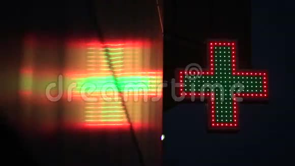 夜间亮起的绿色和红色药房标志视频的预览图