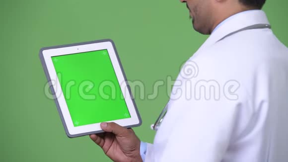 年轻英俊的波斯医生展示数码平板电脑视频的预览图