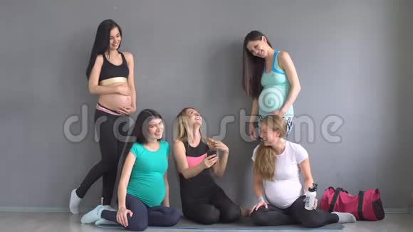 年轻孕妇小组微笑并与教员交流视频的预览图