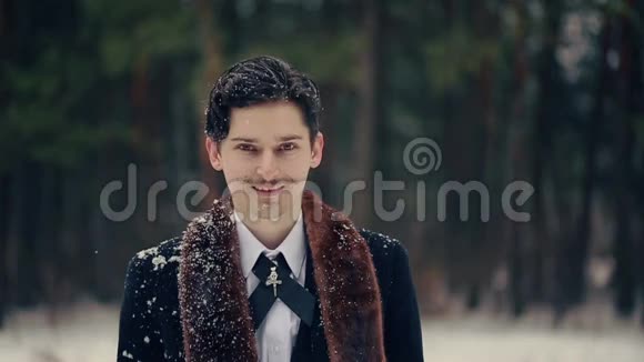 在雪地里微笑的时髦男人视频的预览图