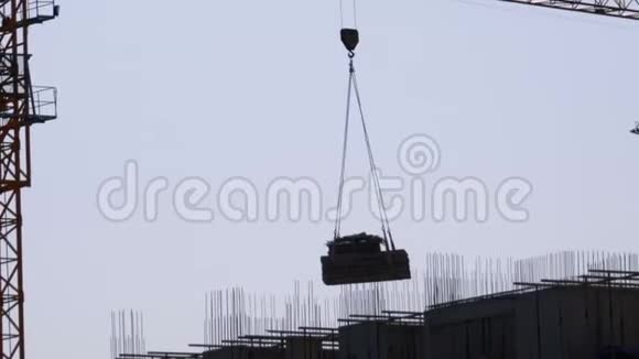 建筑工地上的塔吊在高层建筑上吊起一个荷载视频的预览图