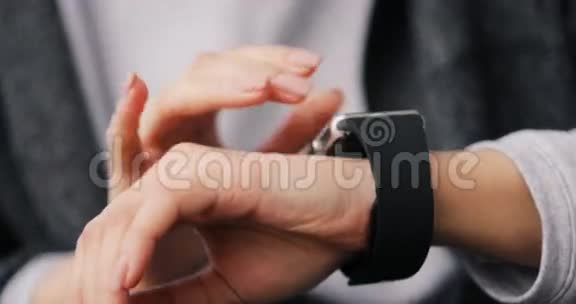 年轻女子在可穿戴智能手表电脑设备上做手势智能手表关闭双手视频的预览图