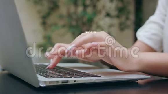 女人手在房间里的笔记本电脑上打字视频的预览图