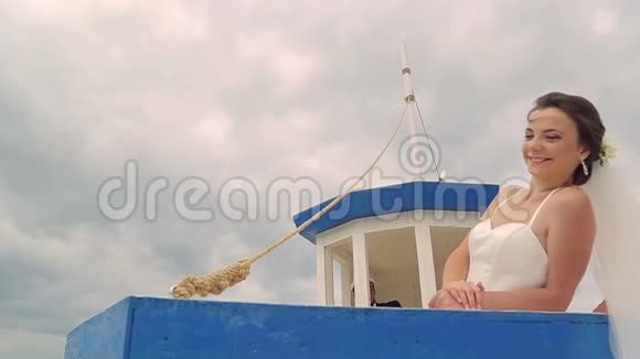 快乐的新娘和新郎在船上航行在年轻人的掌舵下视频的预览图