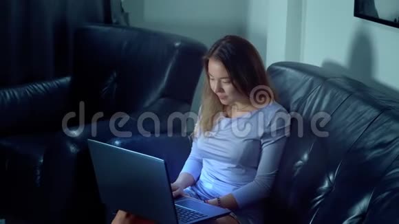 可爱的亚洲女人晚上用笔记本电脑视频的预览图