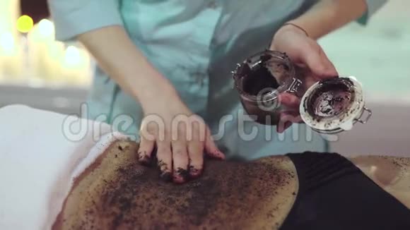 按摩师双手用咖啡擦洗女人的身体视频的预览图