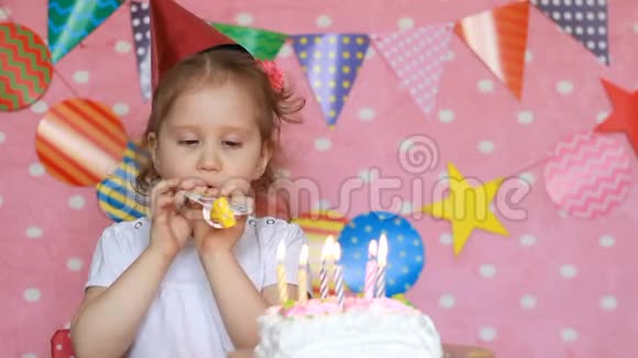 生日快乐可爱的孩子许愿在聚会上吹灭蛋糕上的蜡烛有趣的小女孩和假期粉红色视频的预览图