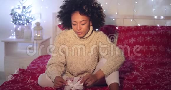单身女子抱着圣诞礼物躺在床上视频的预览图