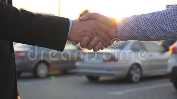 日落时分在户外进行商务握手两个商人在停车场互相问候男性手臂晃动视频的预览图