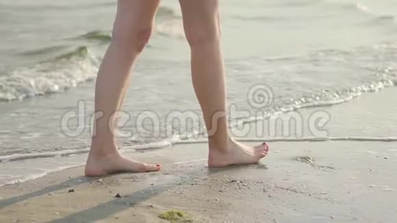 海浪中的女性腿靠近女人的腿在水中行走动作缓慢视频的预览图