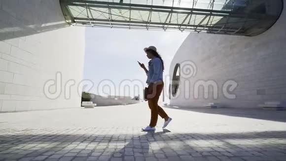 女人在现代建筑之间行走视频的预览图
