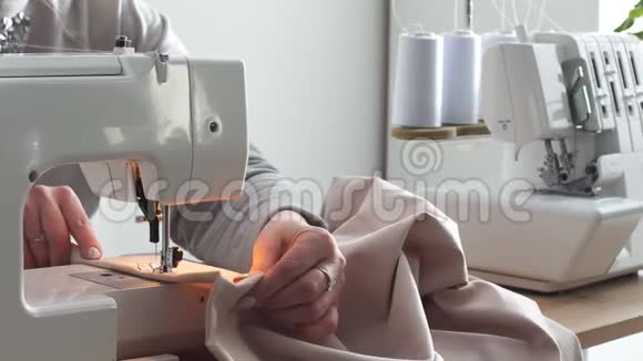 一名妇女用缝纫机缝制粉红色棉花的特写镜头视频的预览图