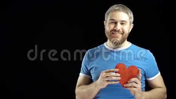 穿蓝色t恤的快乐男人拥有一个红色的心形爱情单身浪漫约会关系概念黑色视频的预览图