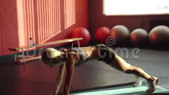 运动垫上的女运动员做腹部运动肌肉女运动员做腹肌锻炼视频的预览图