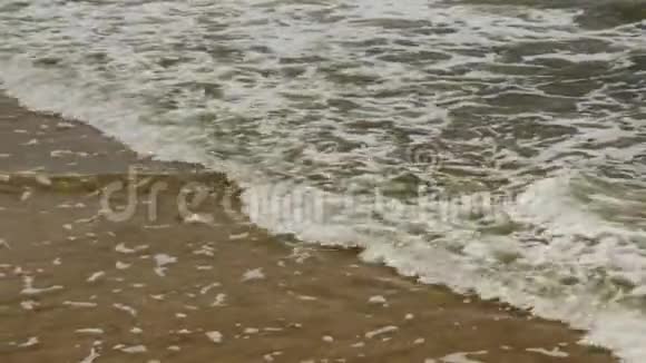 阳光明媚的夏日海浪泡沫洗海滩视频的预览图