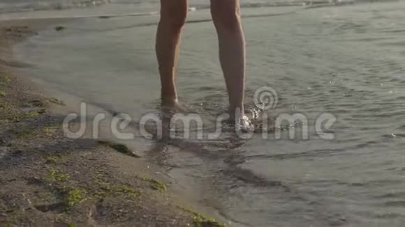海浪中的女性腿靠近女人的腿在水中行走动作缓慢视频的预览图