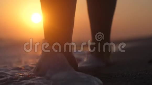 快乐的年轻女子在令人惊叹的金色夕阳下光着脚在大海上奔跑和跳跃慢动作1920x1080视频的预览图