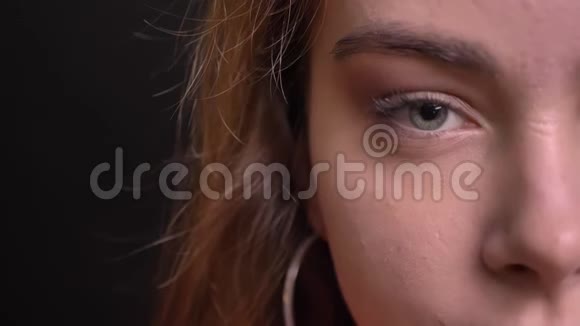 一张年轻美丽的白种人女性脸的特写半脸肖像灰色的眼睛直视着镜头视频的预览图