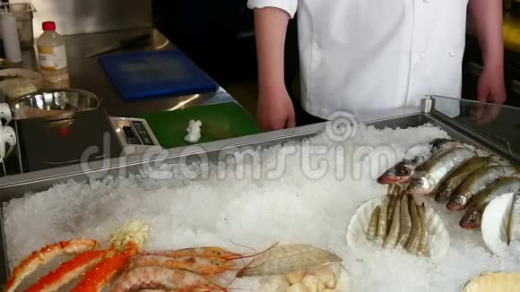 厨师的双手将鲜虾和牡蛎放在海鲜餐厅的冰上视频的预览图