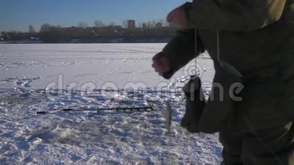 老人在冬天钓鱼时钓到了鱼4K视频的预览图