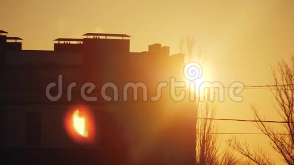 日落时城市景观轮廓多层建筑清晨黎明太阳从屋后向外望视频的预览图