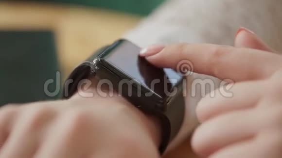 宏拍了一个年轻女人手她使用了一个新的小玩意一个智能手表视频的预览图