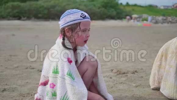 小女孩坐在沙滩上炎炎夏日视频的预览图