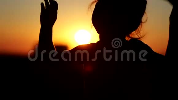 小女孩在阳台的夕阳下跳舞剪影特写镜头视频的预览图