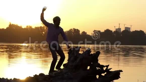 在灿烂的夕阳下快乐的人在湖畔跳舞视频的预览图