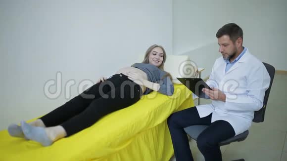 医生检查一名孕妇并将结果写在医疗卡上视频的预览图