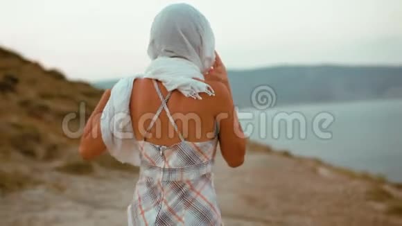 瘦小的女孩子戴着头巾穿着山上的歌走向大海视频的预览图