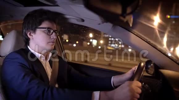 戴眼镜的年轻商人在夜城开车视频的预览图