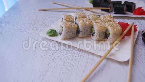 在一个白色时尚的木桌上日本餐厅里有两个寿司卷多利射击视频的预览图