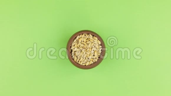 一个装满大麦粒的陶罐放大孤立的绿色屏幕视频的预览图