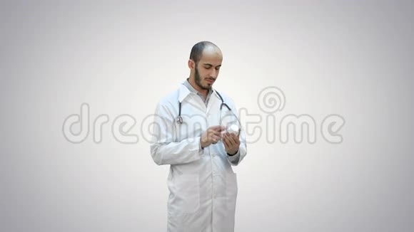 男医生在白色背景上仔细阅读一瓶药丸的药品标签视频的预览图