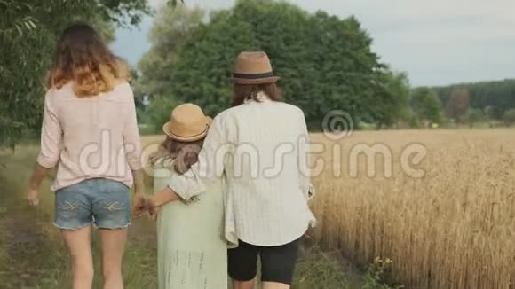 家庭母亲和孩子两个女儿一起走在乡间小路上后景视频的预览图