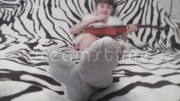 女孩用吉他在背景中用袜子移动腿视频的预览图