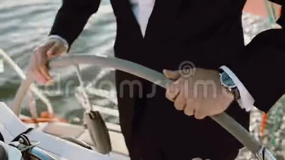 船长站在方向盘后面年轻的商人在阳光明媚的日子驾驶游艇视频的预览图