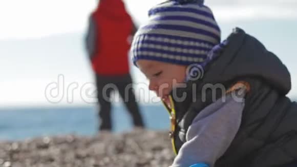 两个兄弟穿着暖和的衣服在海滩上玩耍视频的预览图