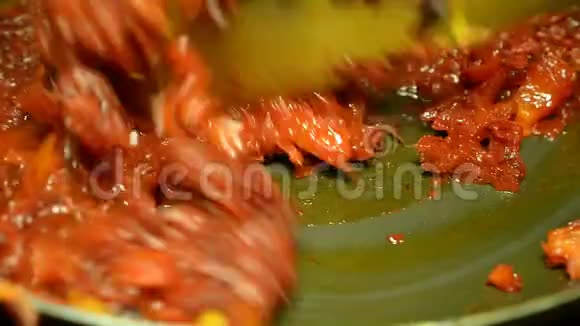 细碎的甜菜和胡萝卜用油煎锅煎用木抹子搅拌视频的预览图