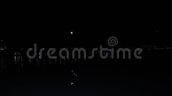 平静的峡湾带着满月的倒影和背景中的tromsdalen视频的预览图
